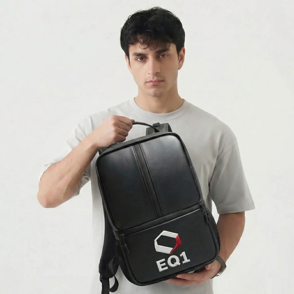 Man holding black EQ1 backpack with modern minimalist design against white background