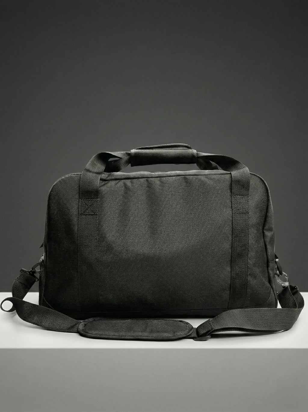 Side view of black duffel bag with sturdy handles and structure