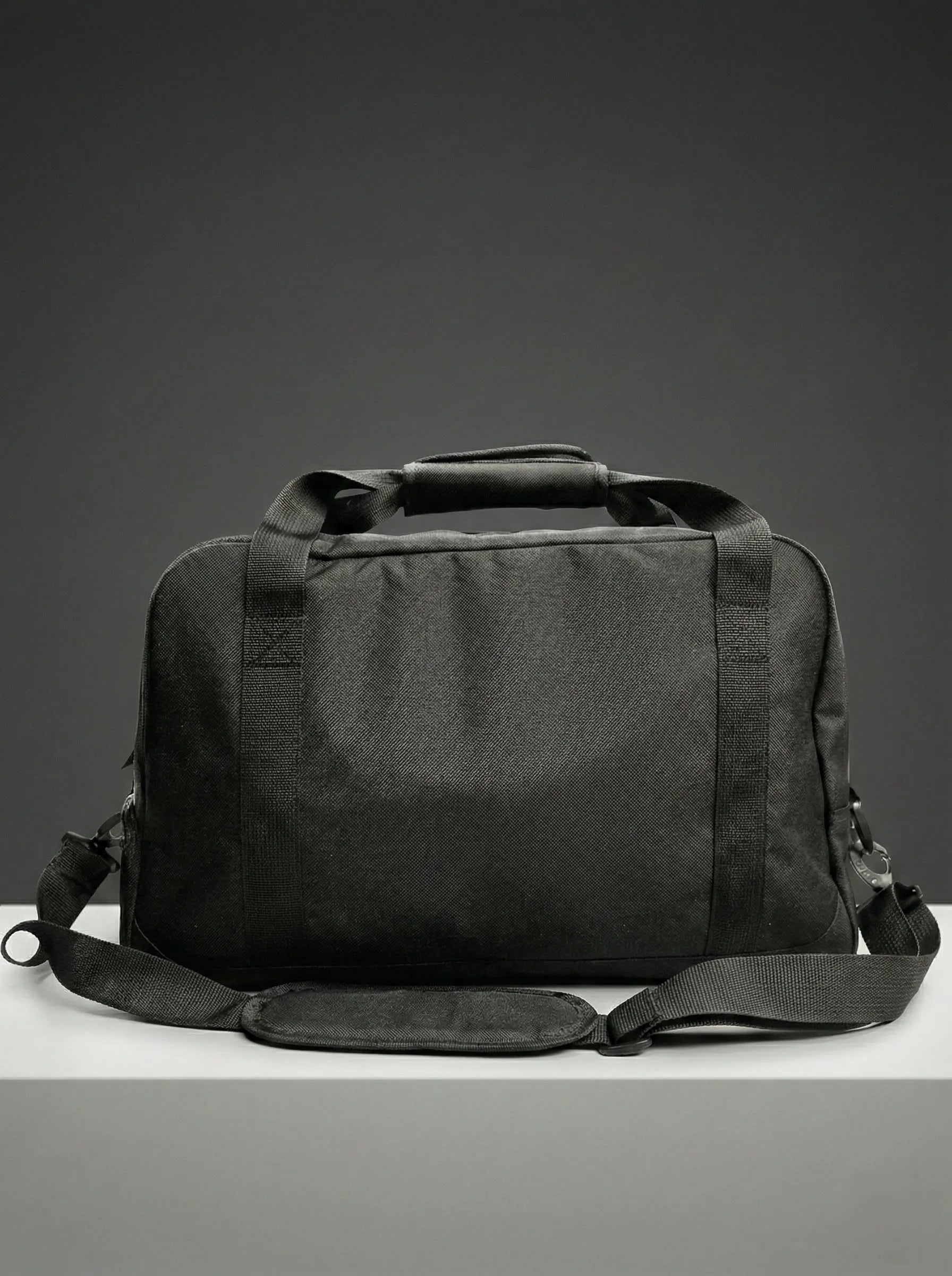 Side view of black duffel bag with sturdy handles and structure