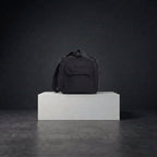 Side view of black duffle bag with straps and compartments