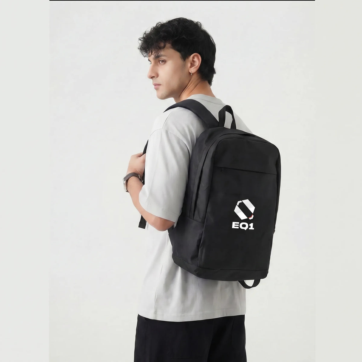 Male model carrying black EQ1 backpack with sleek urban lifestyle design