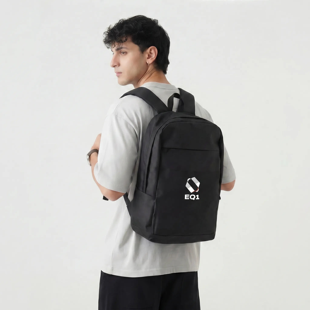 Side view of a person wearing a black EQ1 backpack against white background