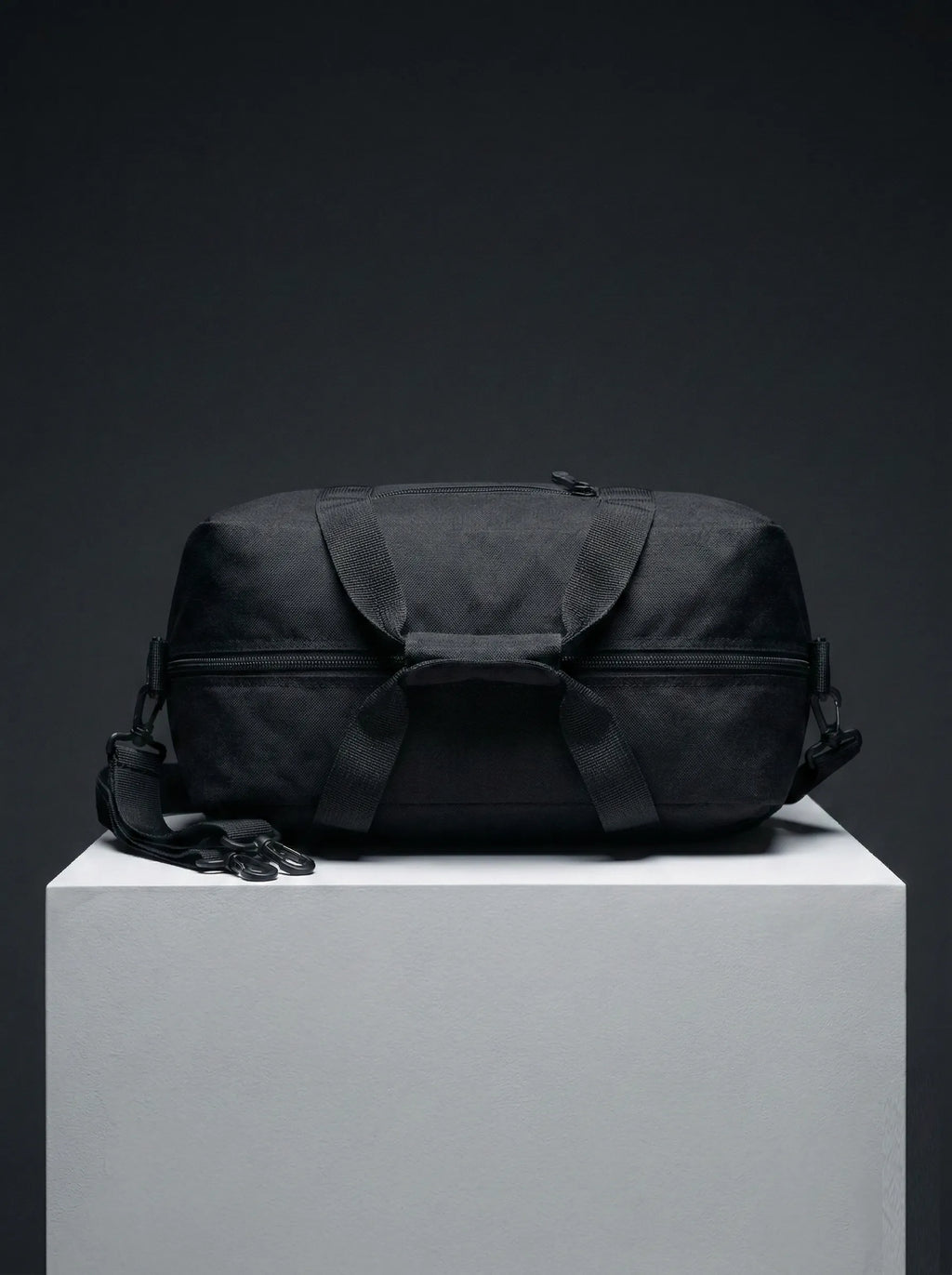 Top view of black EQ1 duffel bag featuring strong handles, zipper closure, and durable travel-ready structure on a white display platform.