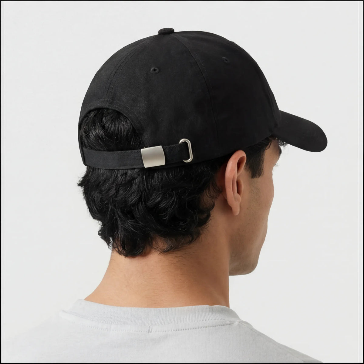 Back side view of black baseball cap with adjustable metal strap closure