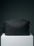 bottom view of black EQ1 duffel bag featuring durable fabric, zipper closure, and compact travel-friendly structure on a white platform.