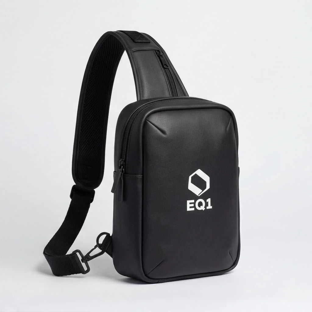 Close-up of black EQ1 sling bag with adjustable strap and zipper compartment detail
