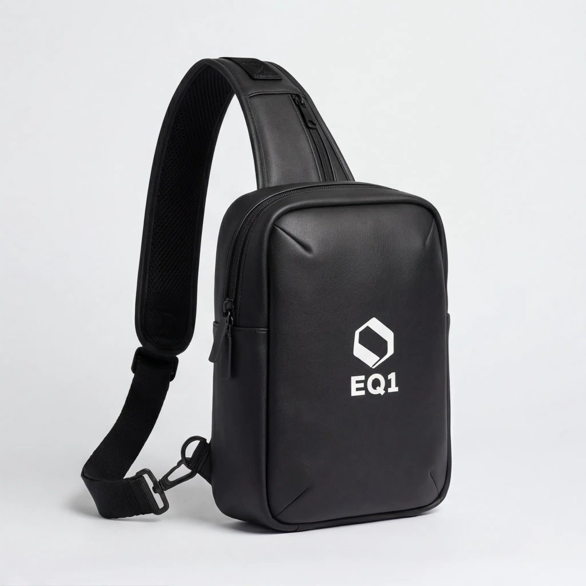 Close-up of black EQ1 sling bag with adjustable strap and zipper compartment detail
