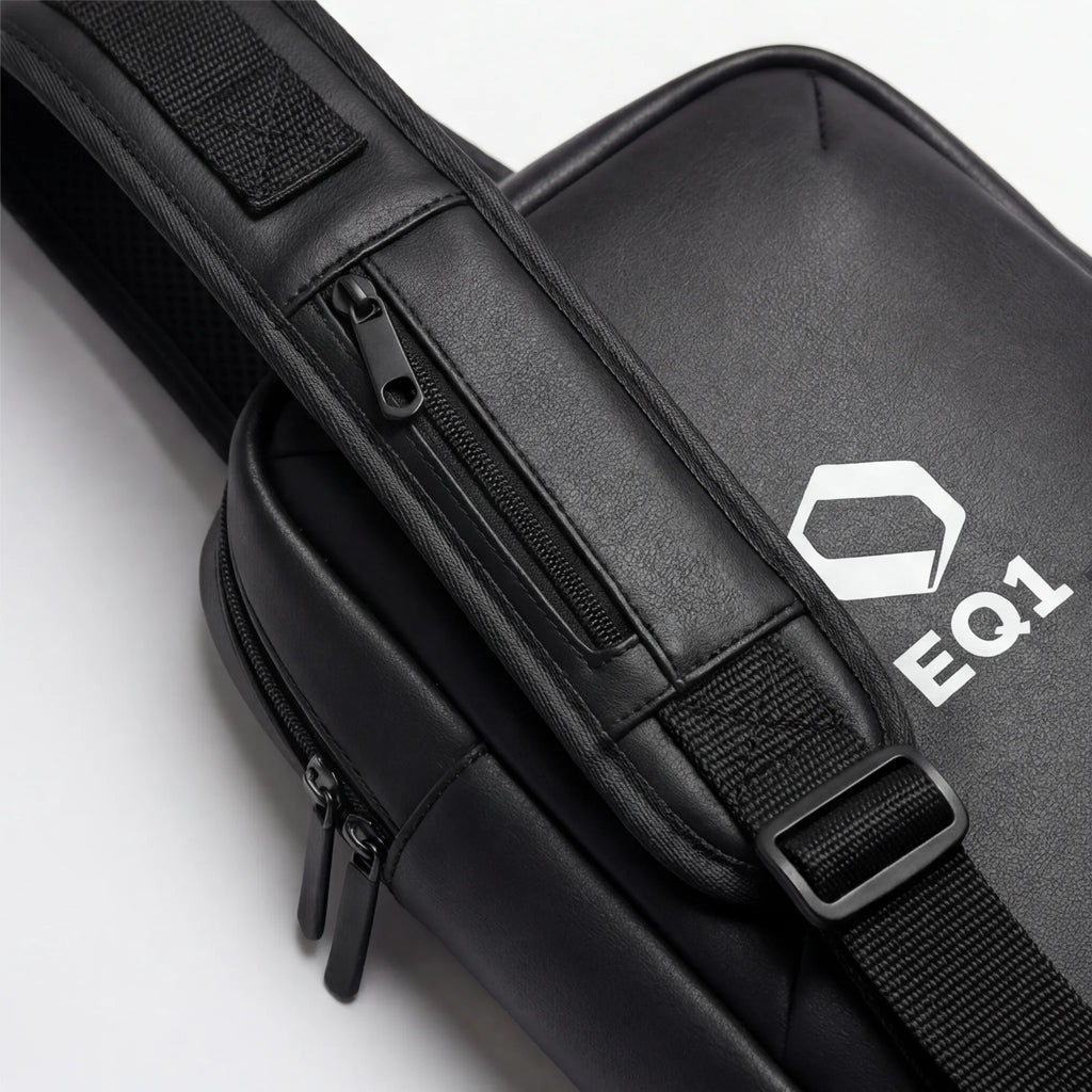 Close-up of black EQ1 sling bag strap with zipper pocket and adjustable buckle