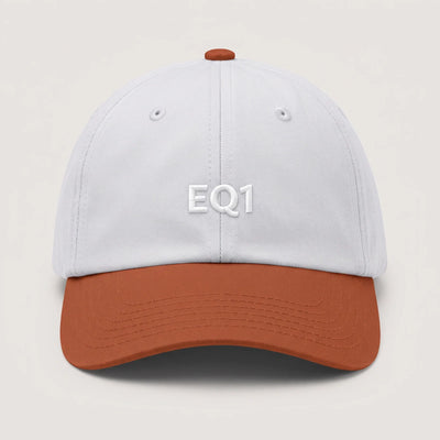 Two tone dad cap with a white crown and a rust peak, EQ1 embroidery on the front
