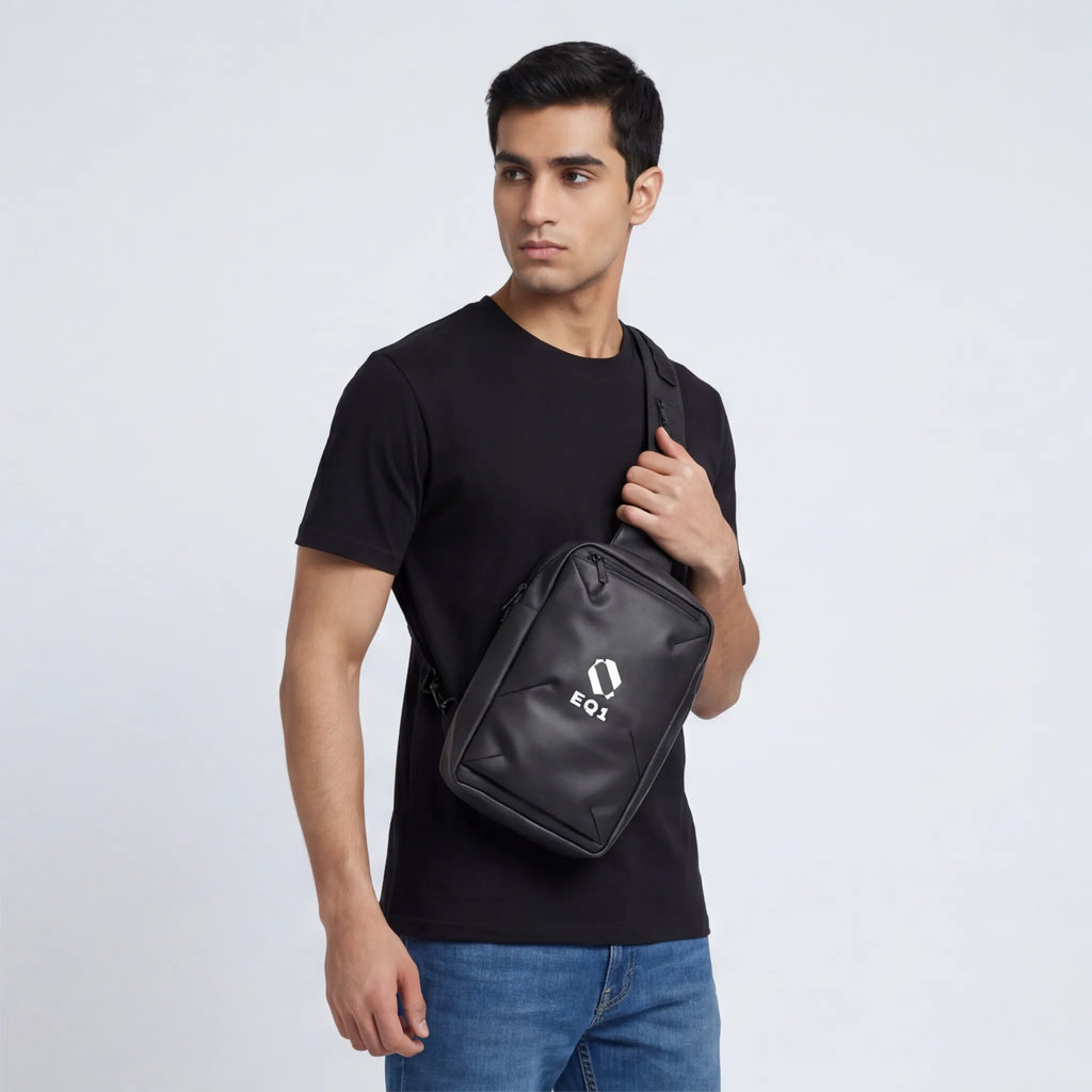 Male model carrying black EQ1 crossbody sling bag with adjustable shoulder strap
